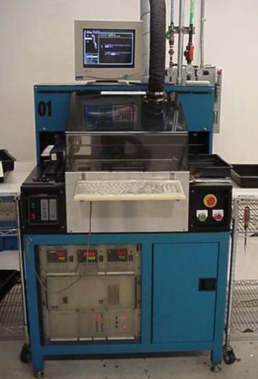 A blue industrial workstation featuring a computer monitor, a protective enclosure, control panels, and a keyboard.