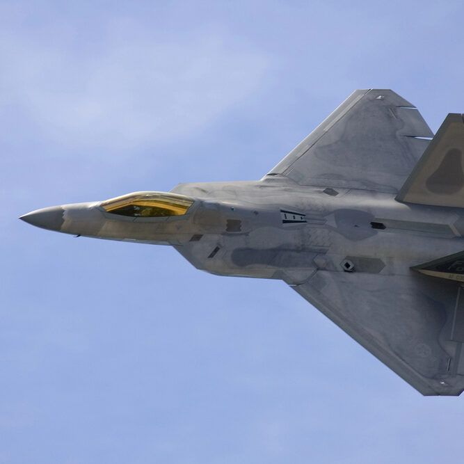 F-22 Raptor fighter jet soaring in a blue sky. 