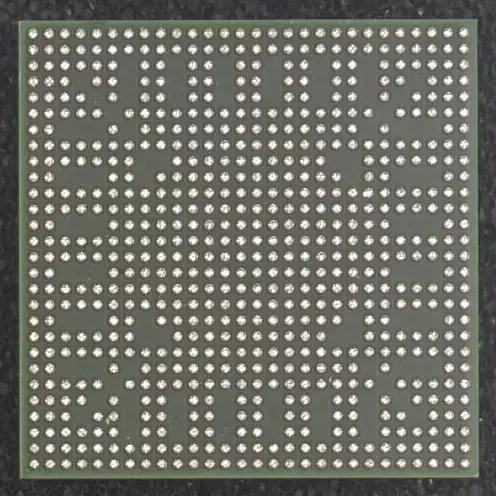 BGA chip, square with numerous evenly spaced solder balls on a green substrate.