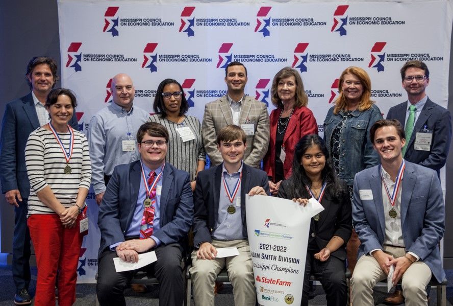 A group of people are posing for a picture in front of a wall.