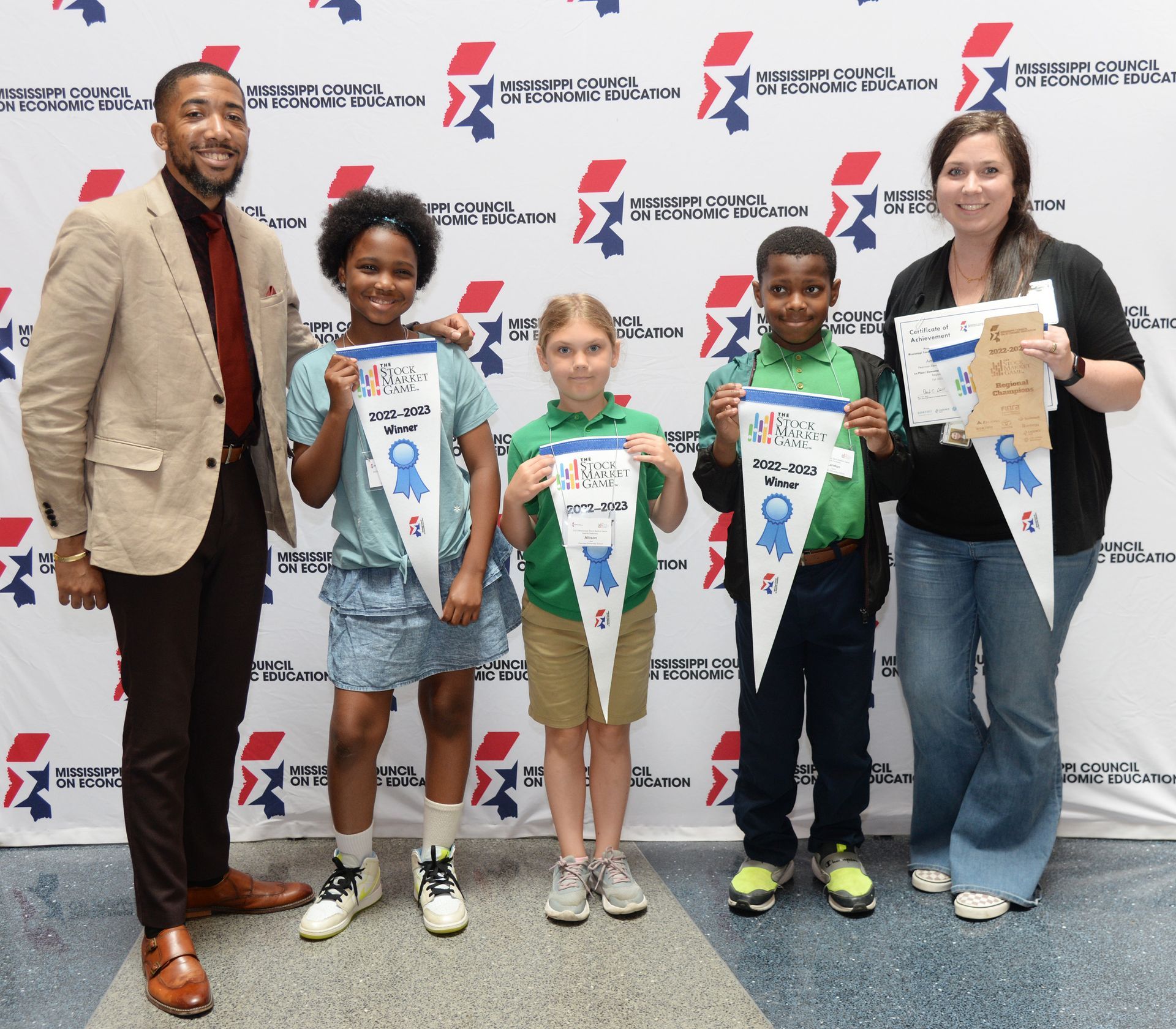 A group of people are posing for a picture while holding awards