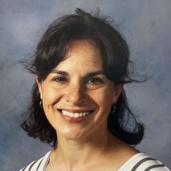 A woman in a striped shirt is smiling for the camera