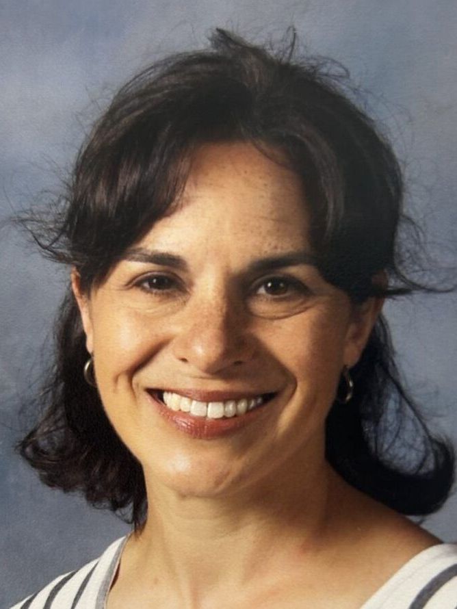 A woman in a striped shirt is smiling for the camera