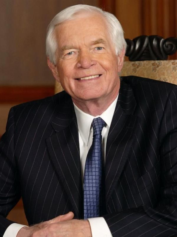 A man in a suit and tie is smiling for the camera