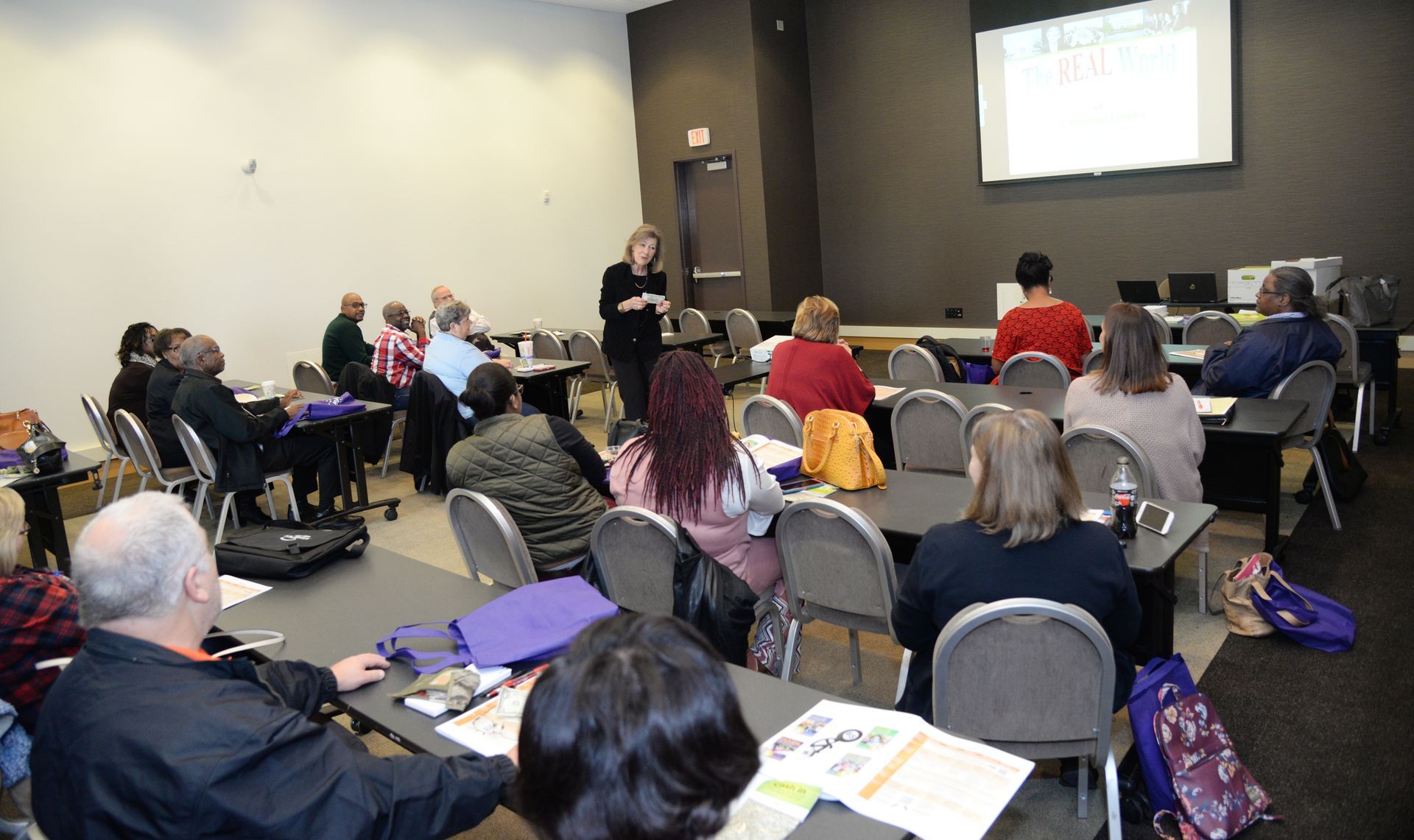 A woman is giving a presentation to a group of people in a conference room.