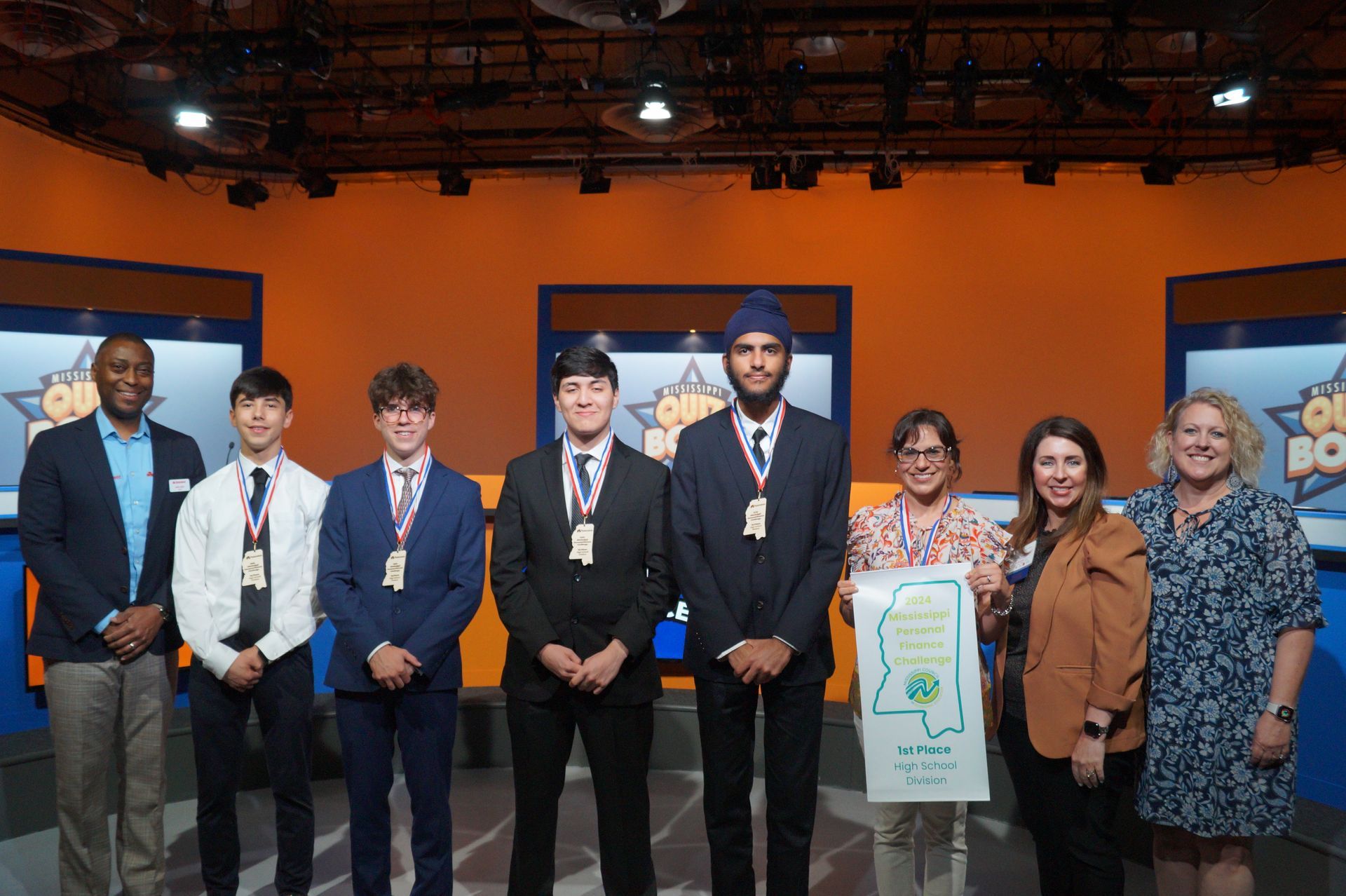A group of people are posing for a picture in a studio.