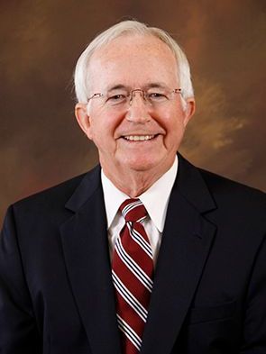 A man in a suit and tie is smiling for the camera.