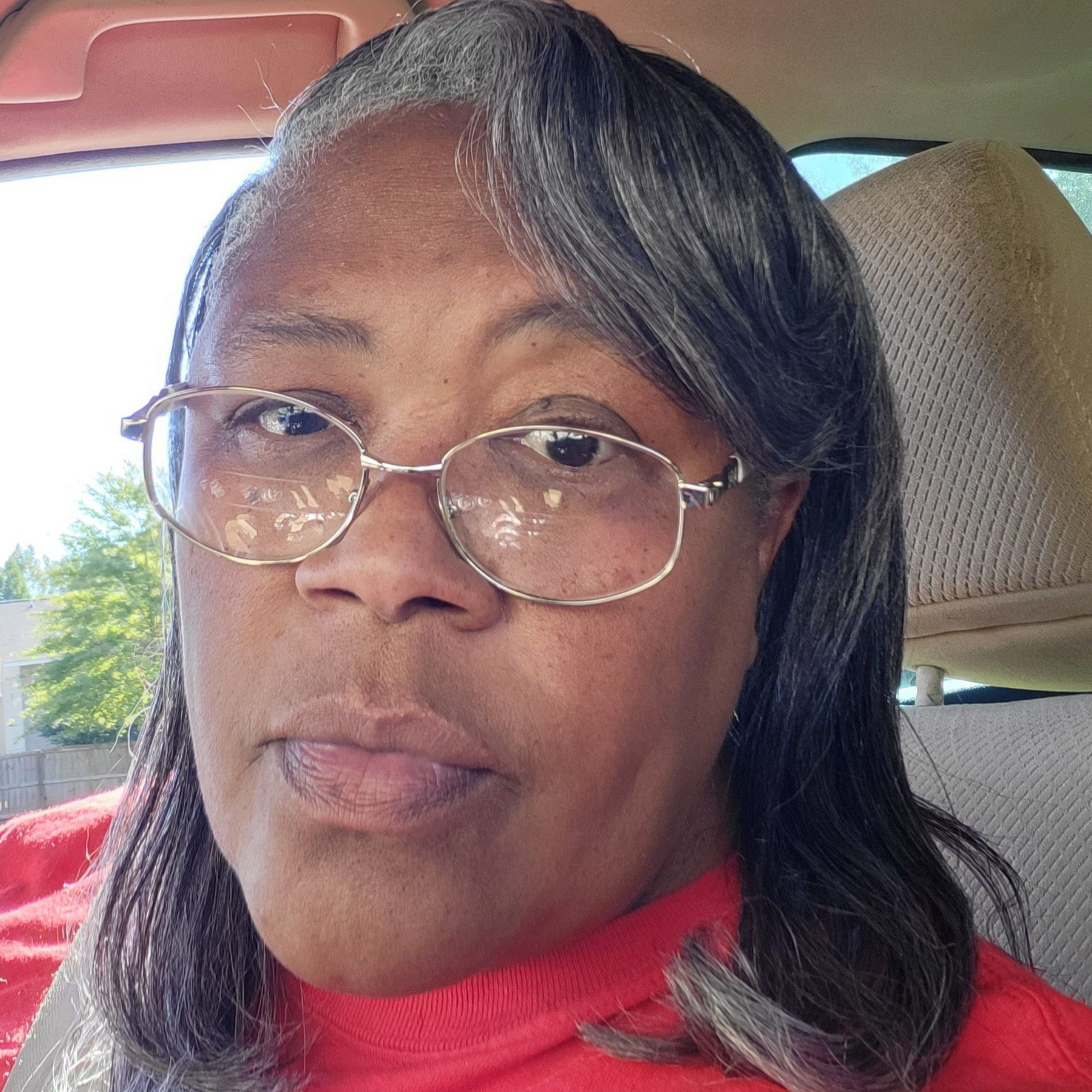 The woman is wearing a red dress and a pearl necklace.