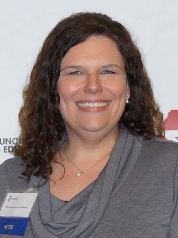 A woman wearing a name tag that says mite smiles for the camera