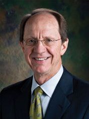 A man in a suit and tie is smiling for the camera.