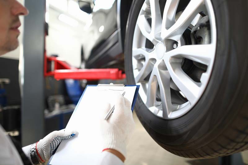 Man Checking Vehicle Tires — Columbiana, AL — Howard Tire Service, Towing and Recovery