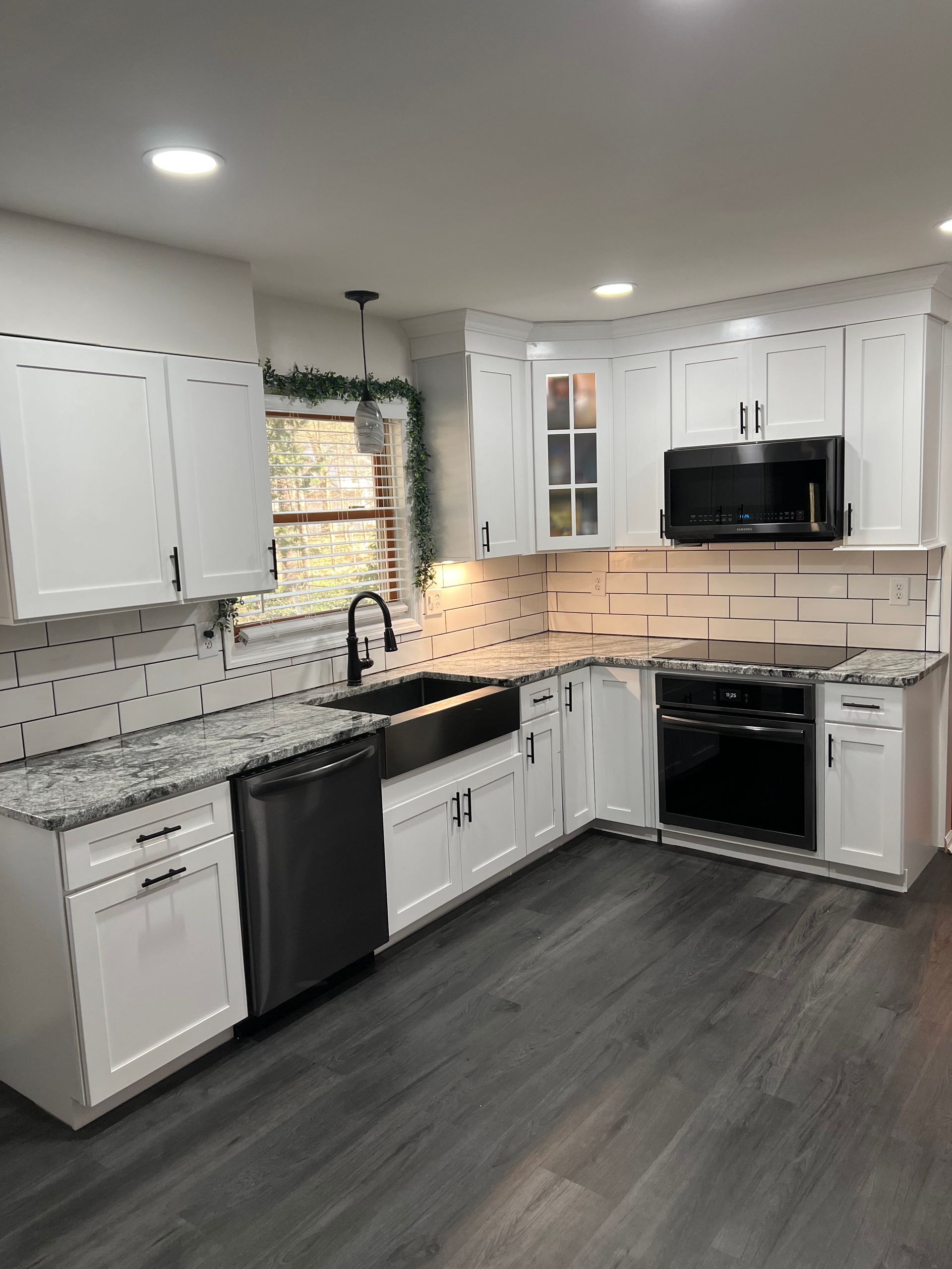 A kitchen with white cabinets and granite counter tops