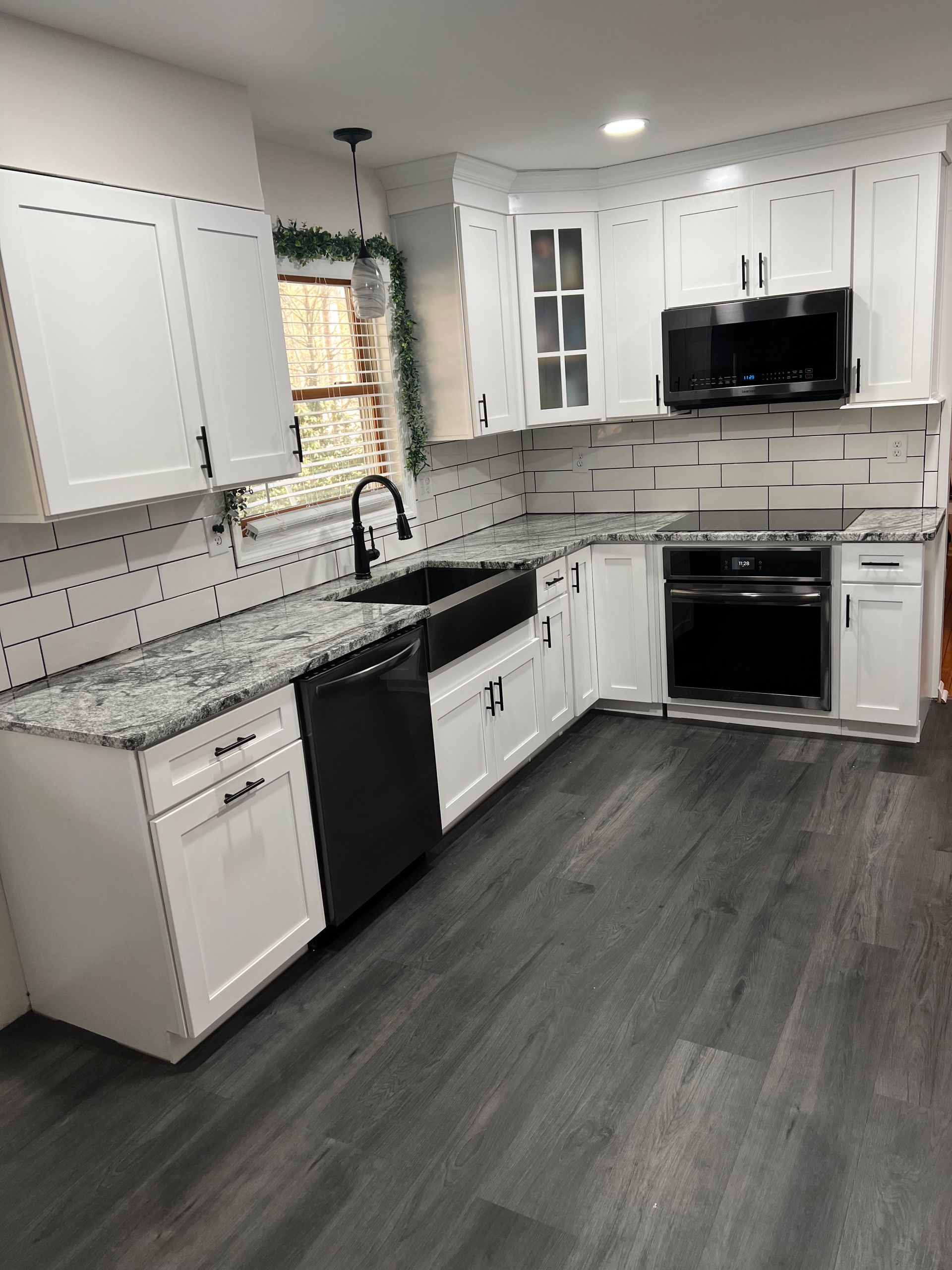 A kitchen with white cabinets and granite counter tops