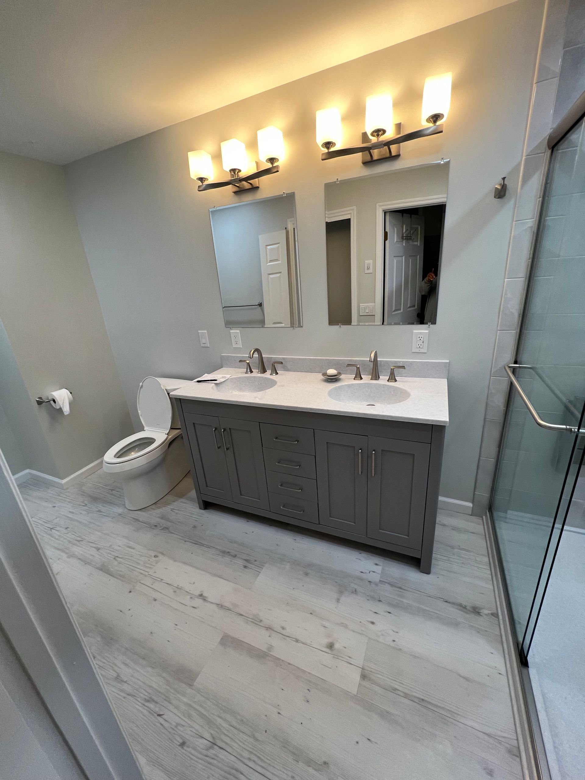 A bathroom with two sinks , a toilet , and a shower.