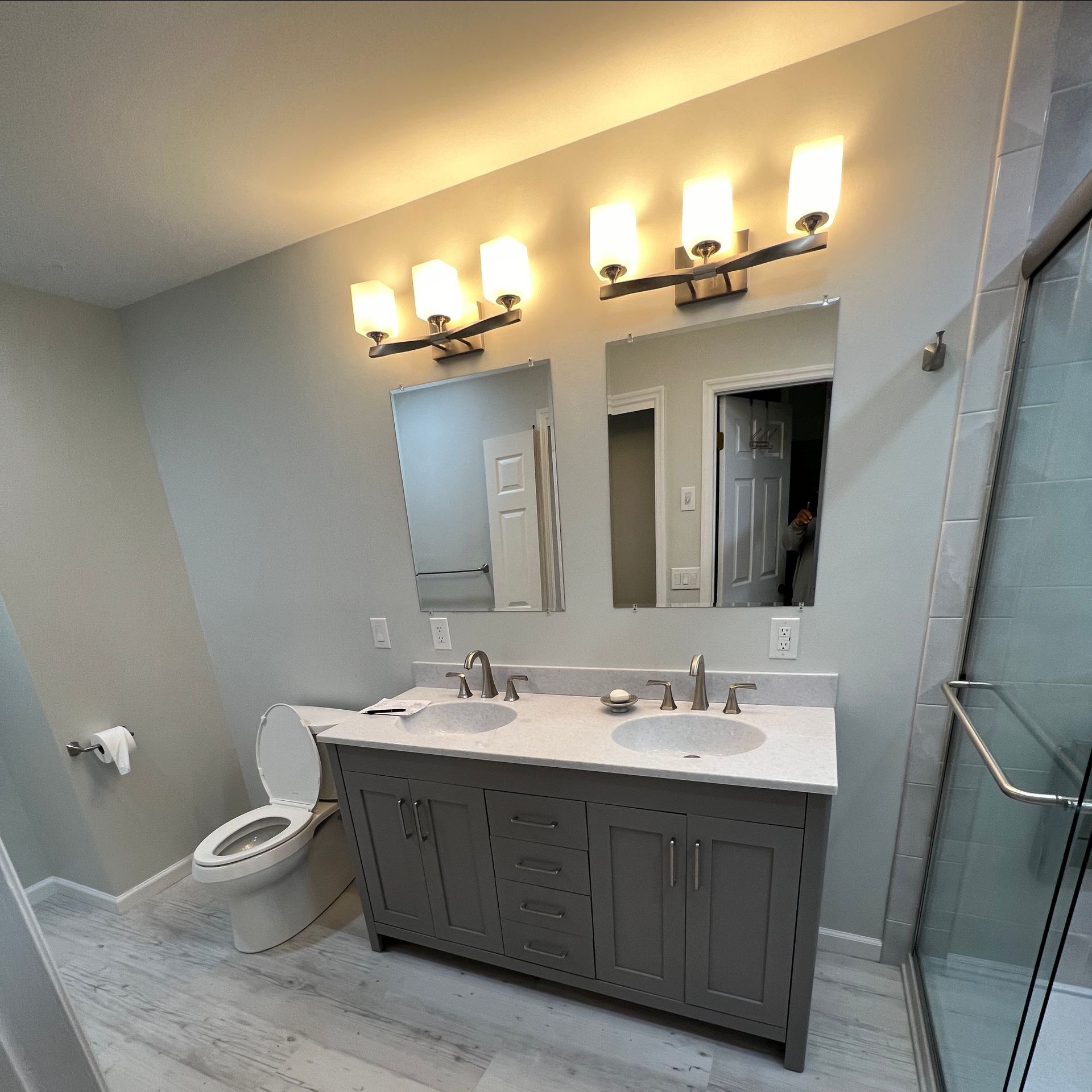A bathroom with two sinks , a toilet , and a mirror.