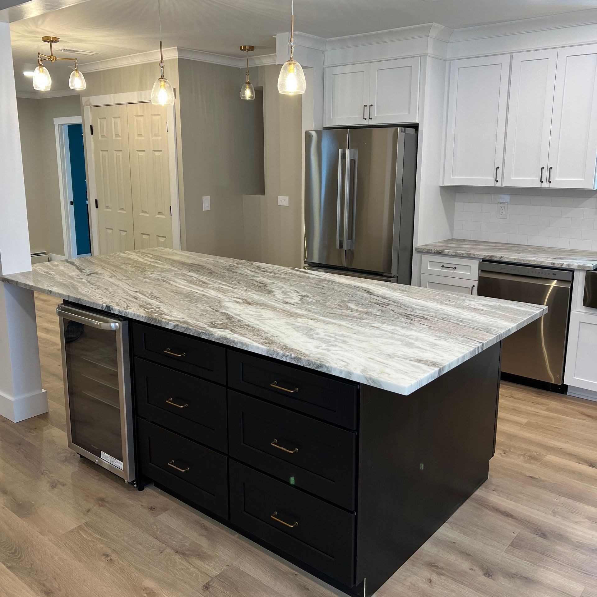 A kitchen with white cabinets , granite counter tops , a stove and a sink.