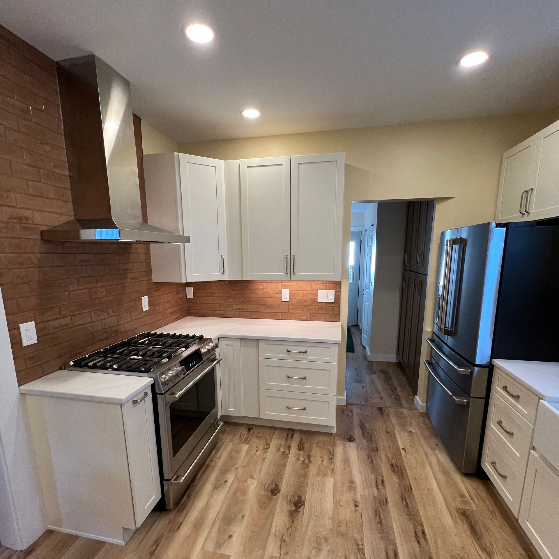 A kitchen with stainless steel appliances and white cabinets