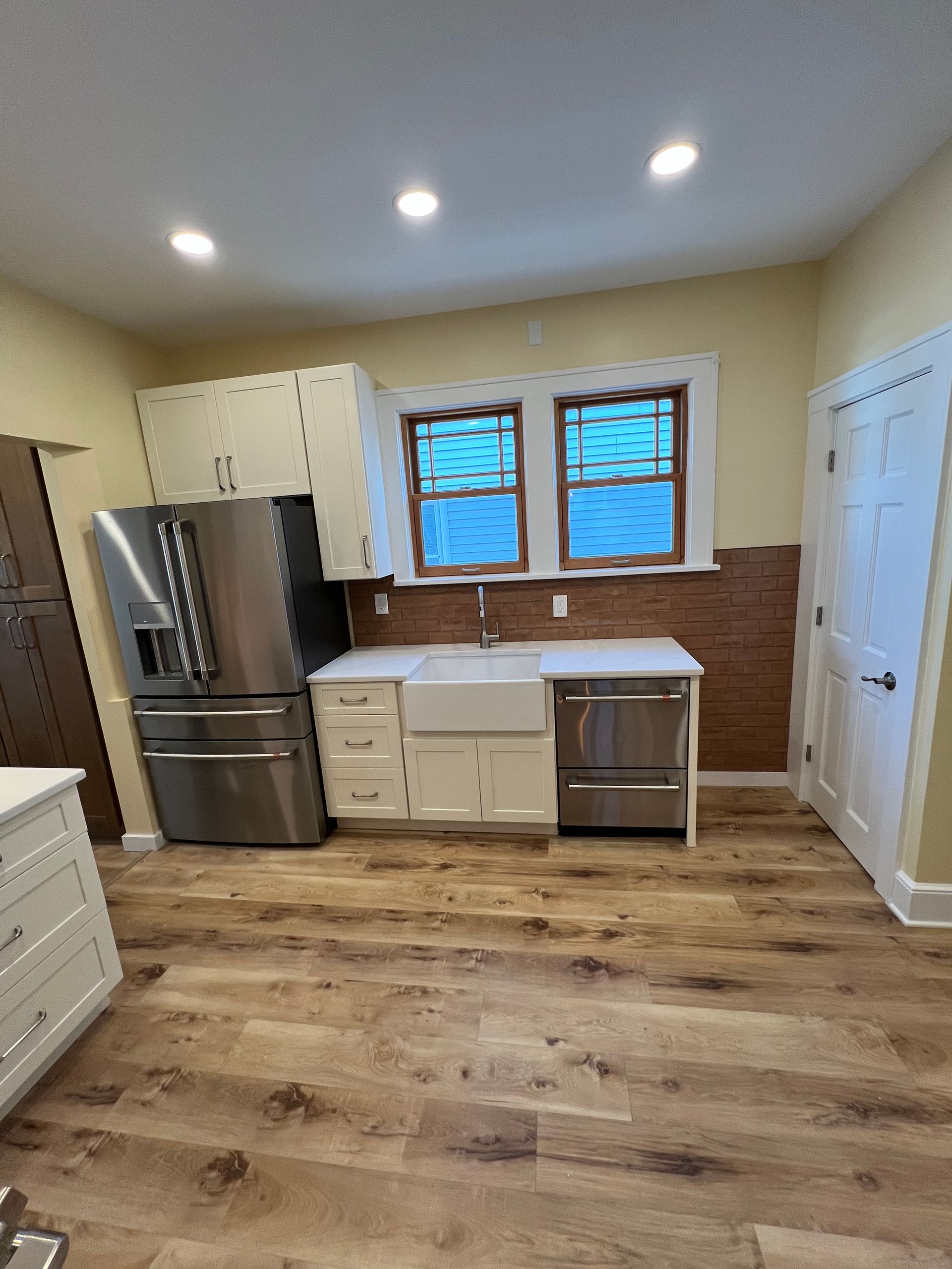 A kitchen with stainless steel appliances and hardwood floors.