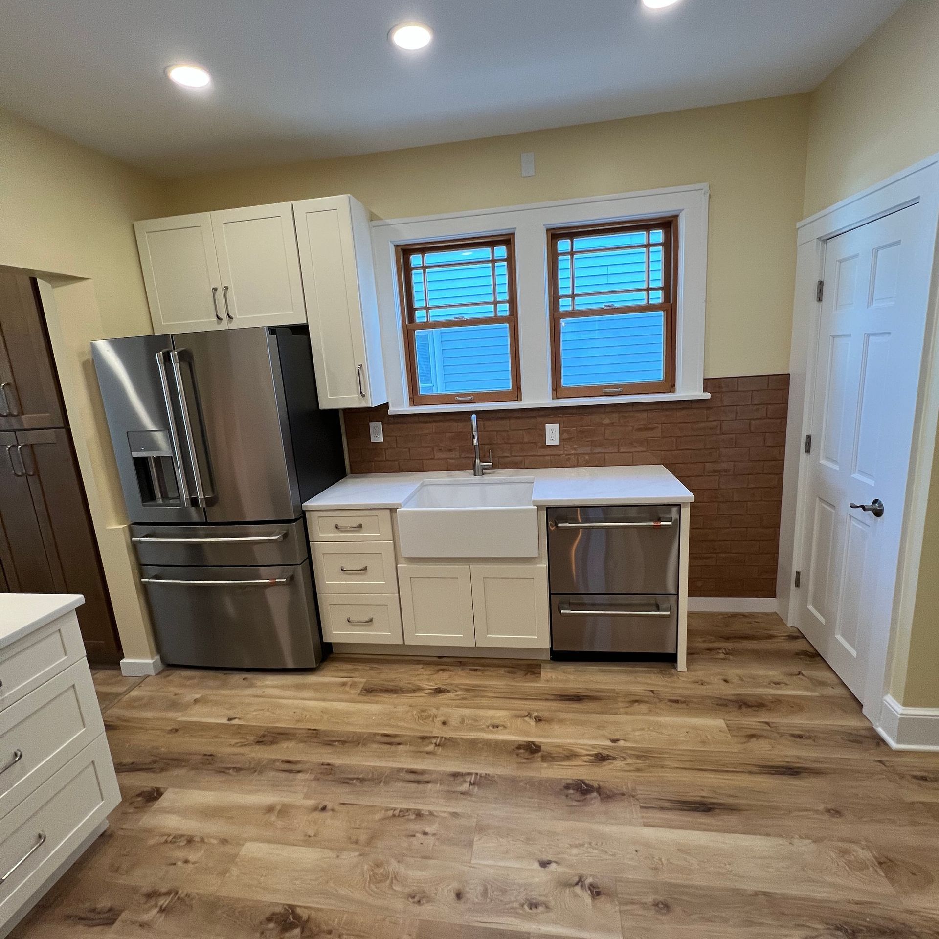 A kitchen with stainless steel appliances and hardwood floors.