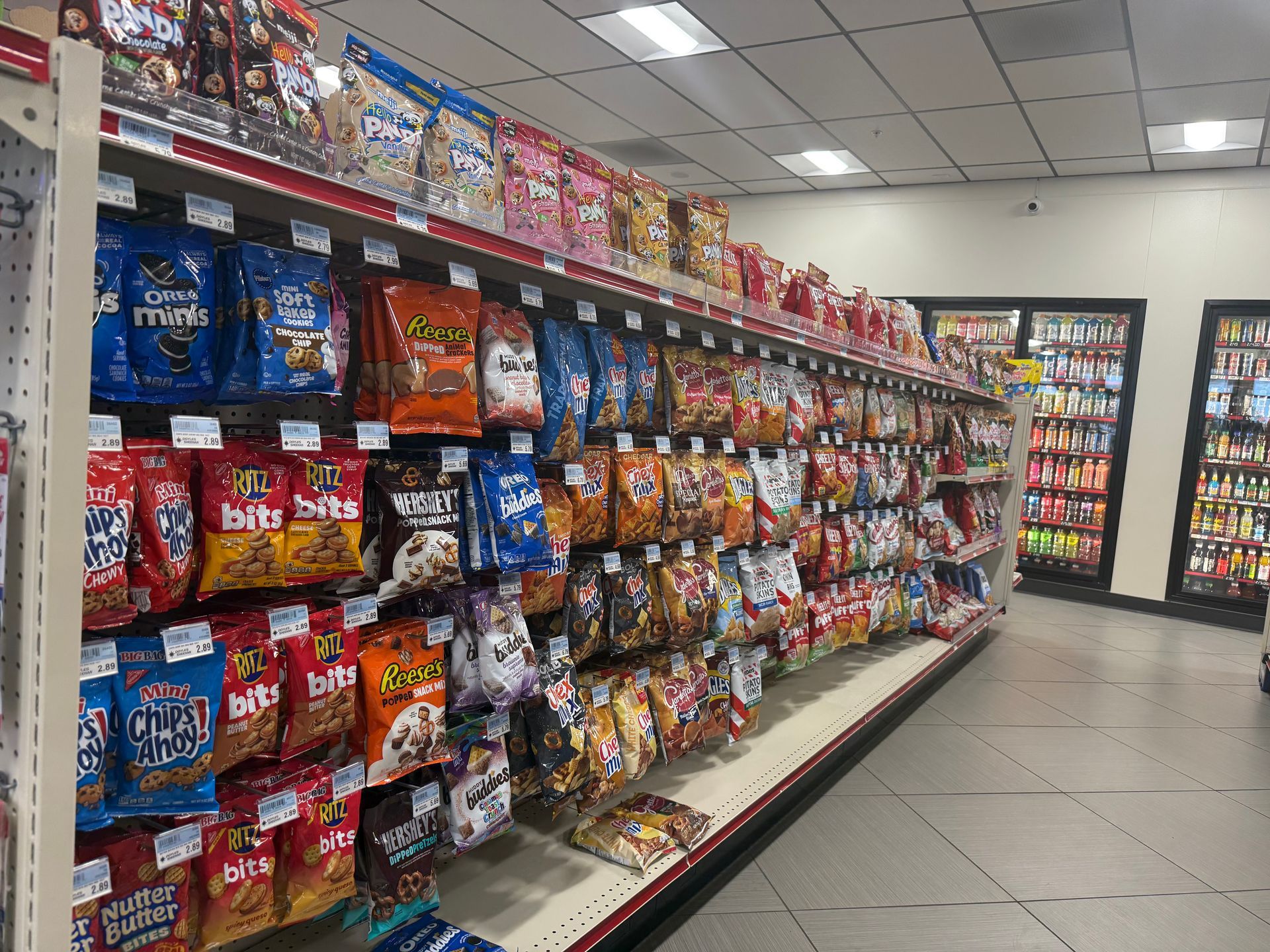 Shelves stocked with various chip and snack bags in a convenience store.
