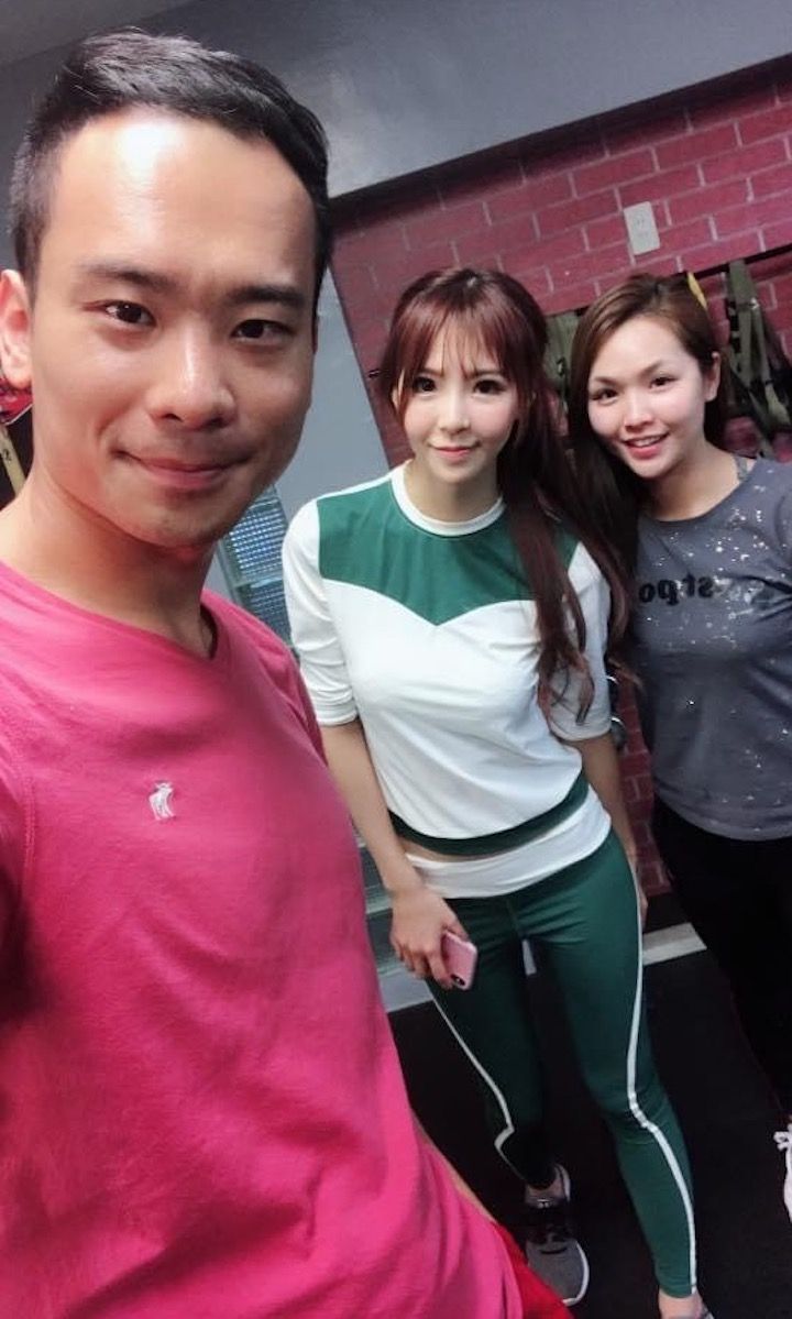 A man and two women are posing for a picture in a gym.