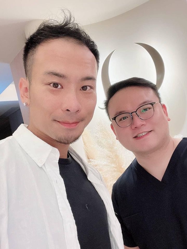 Two men are posing for a picture together and one of them is wearing glasses.