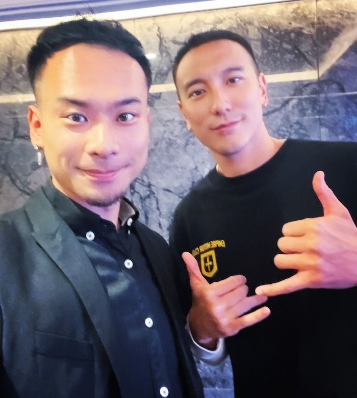 Two men are posing for a picture and one is wearing a shirt that says california