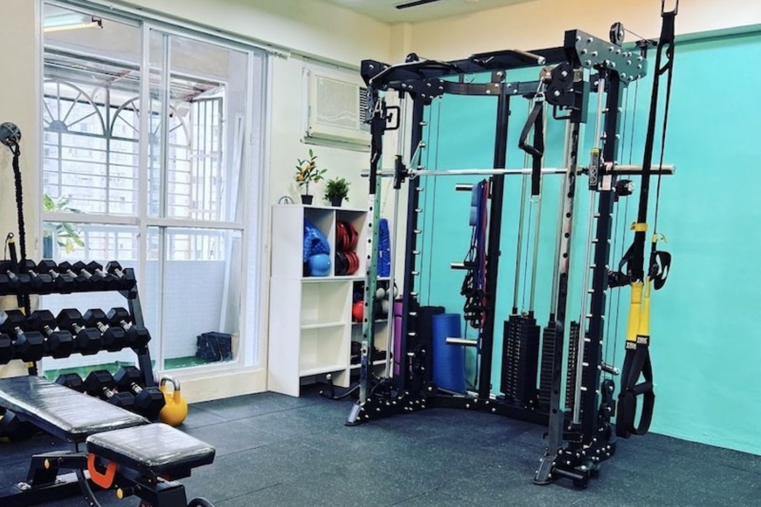 A gym with a lot of equipment and a bench.