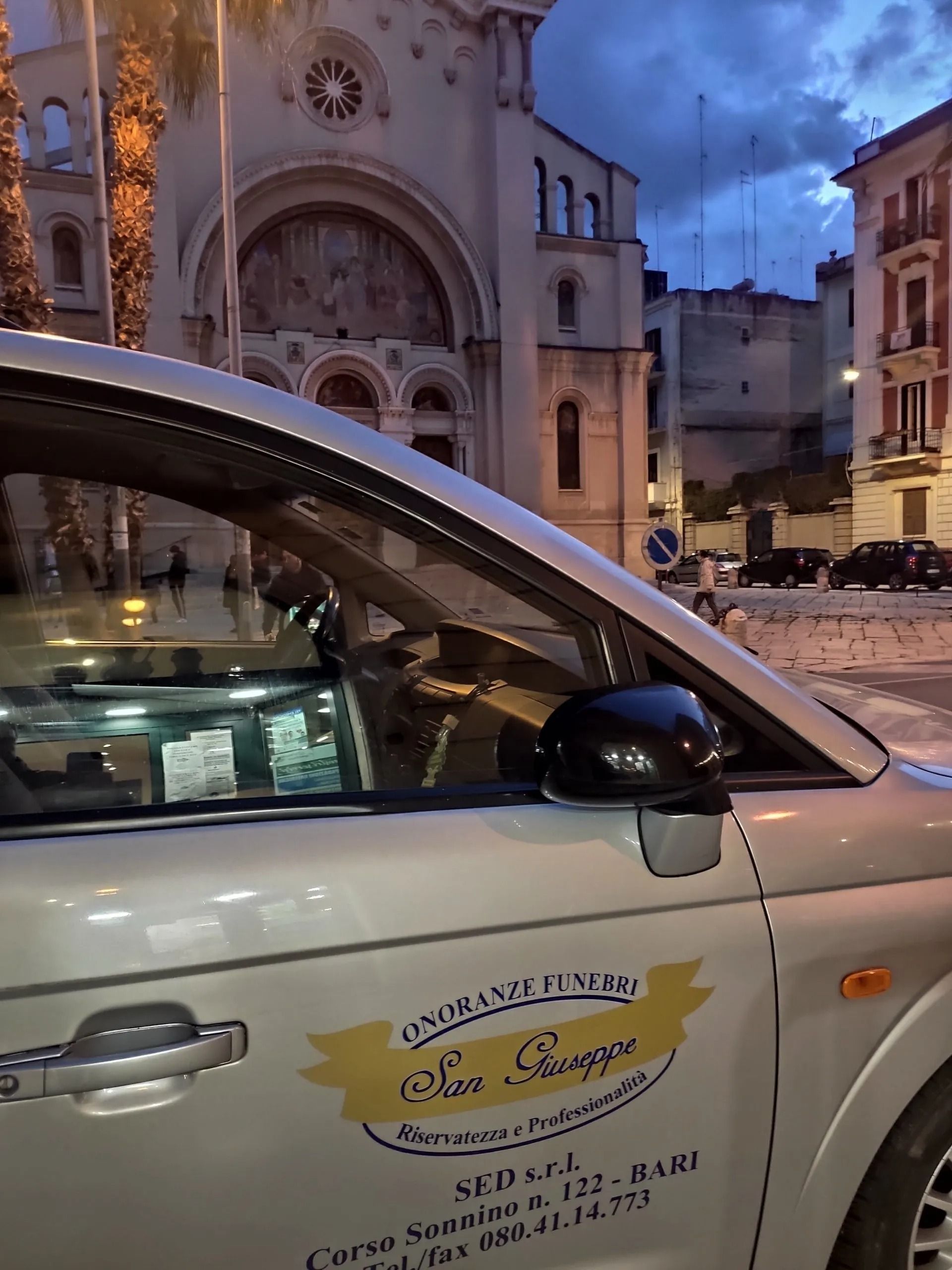 Un'auto bianca è parcheggiata davanti a una chiesa