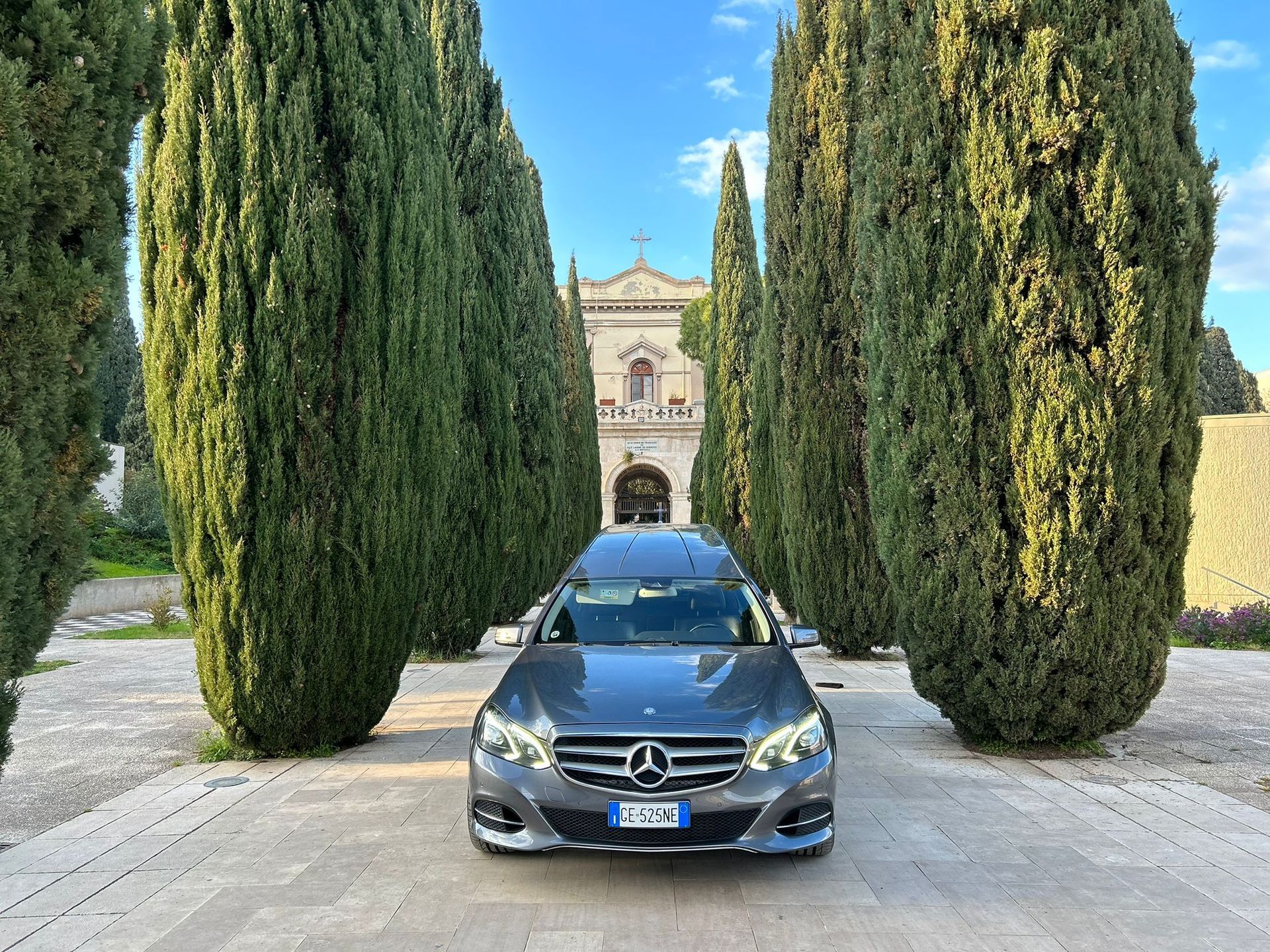 Un'auto funebre mercedes benz è parcheggiata davanti a una casa.