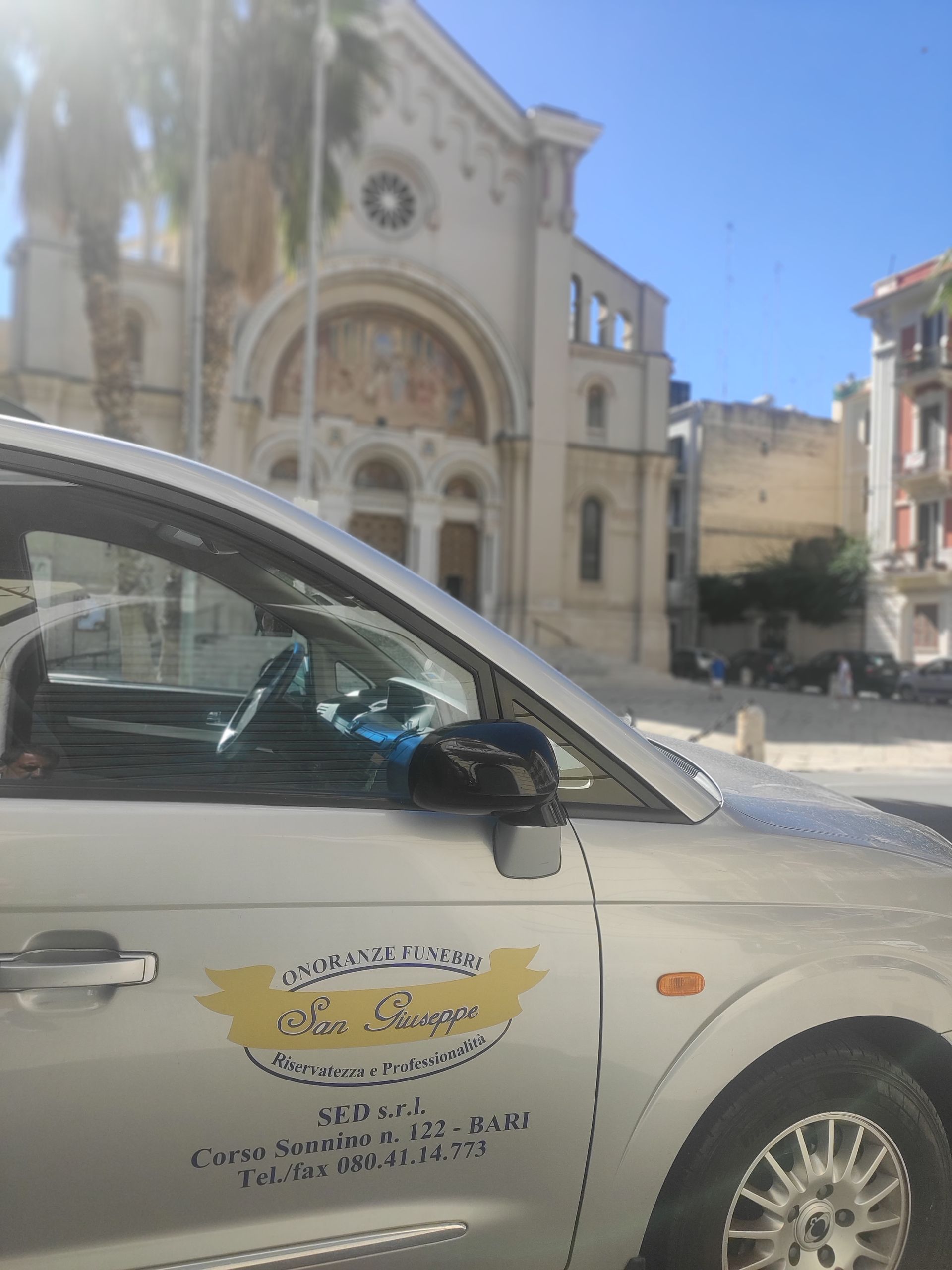 Un'auto bianca è parcheggiata davanti a una chiesa