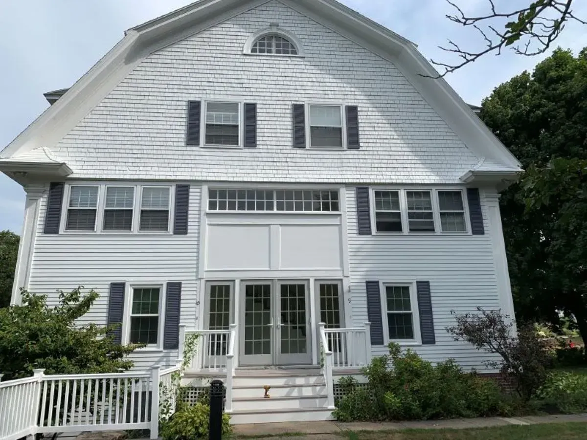 A large white house with blue shutters on the windows