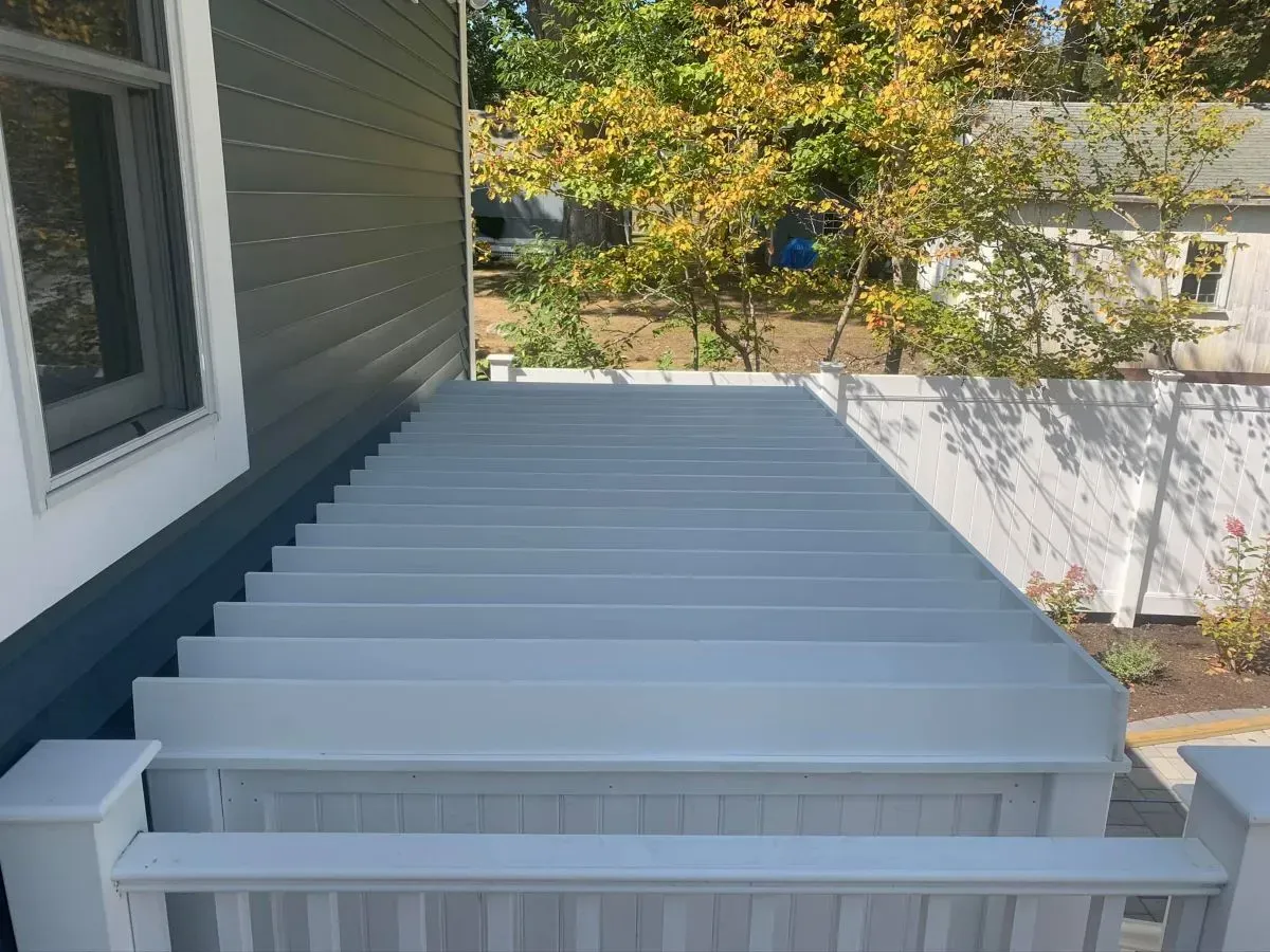 A blue deck with stairs leading up to a house.