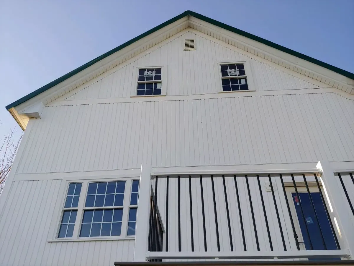 A white house with a balcony and a blue door