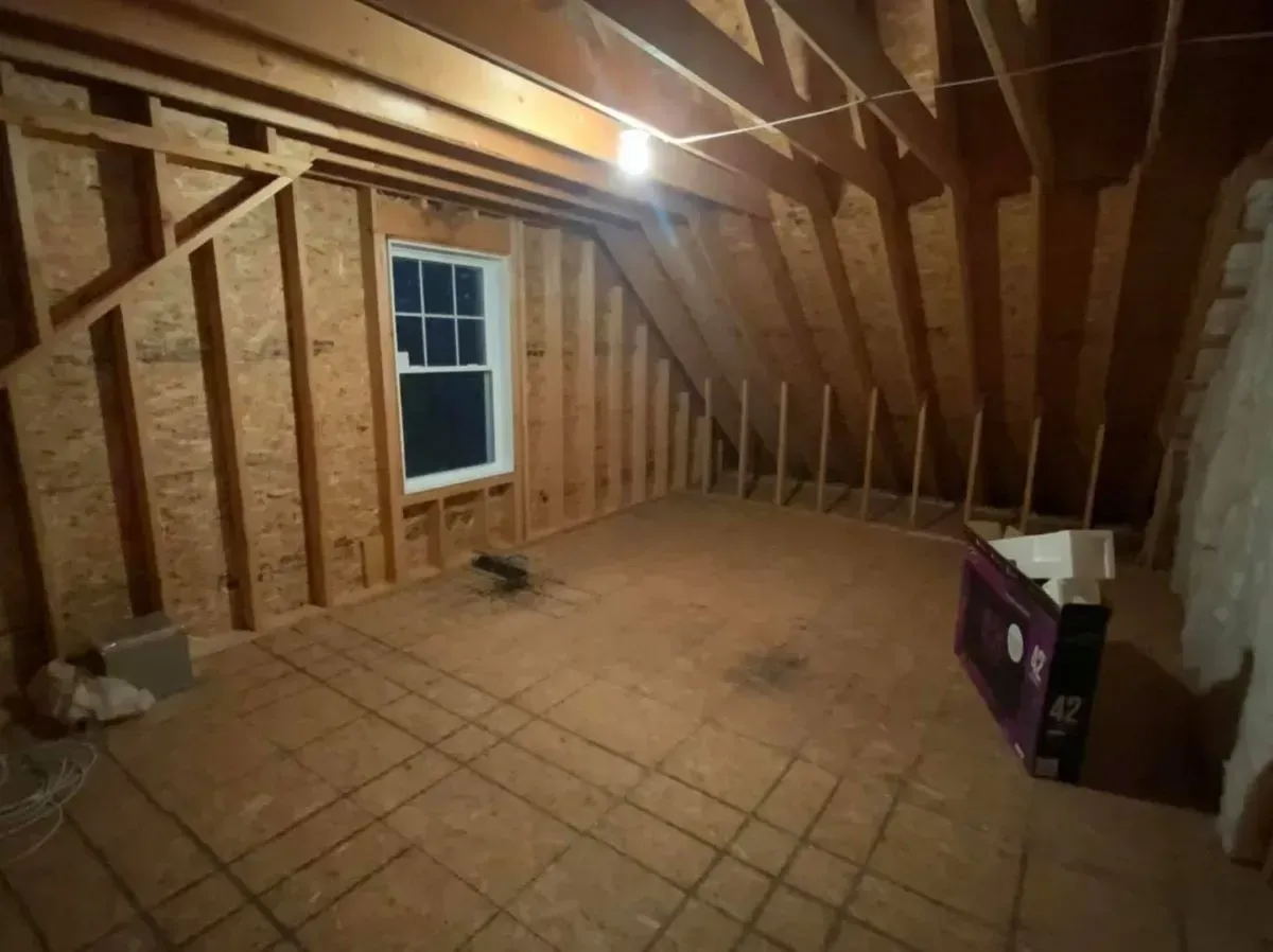 An empty room with a window and a box on the floor.