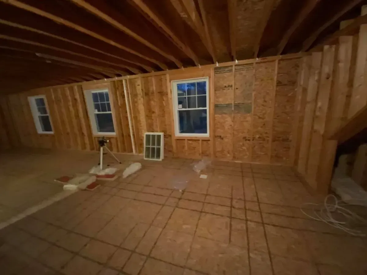 A room with a lot of windows and a fan in it.