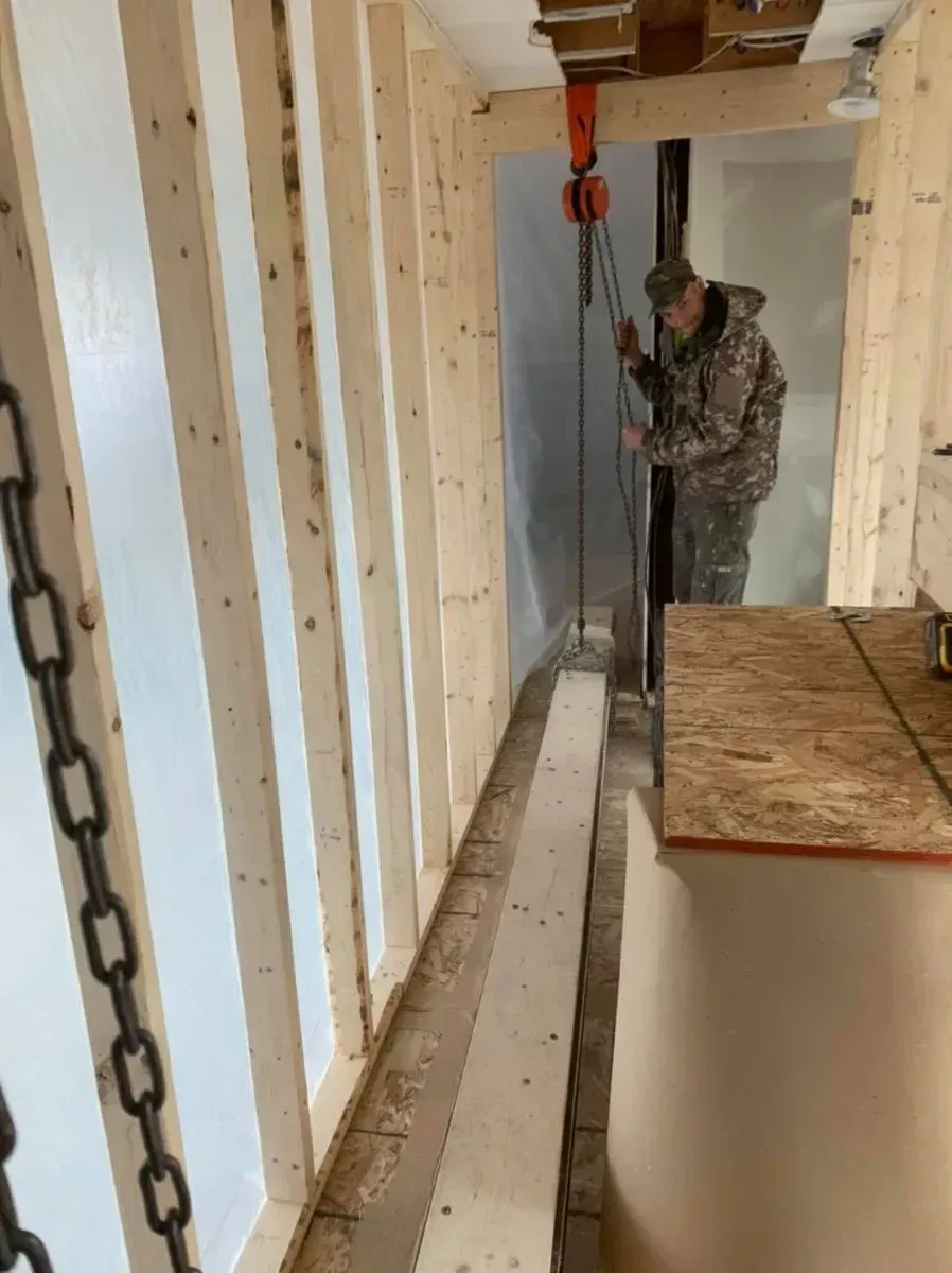 A man is standing in a room holding a crane.