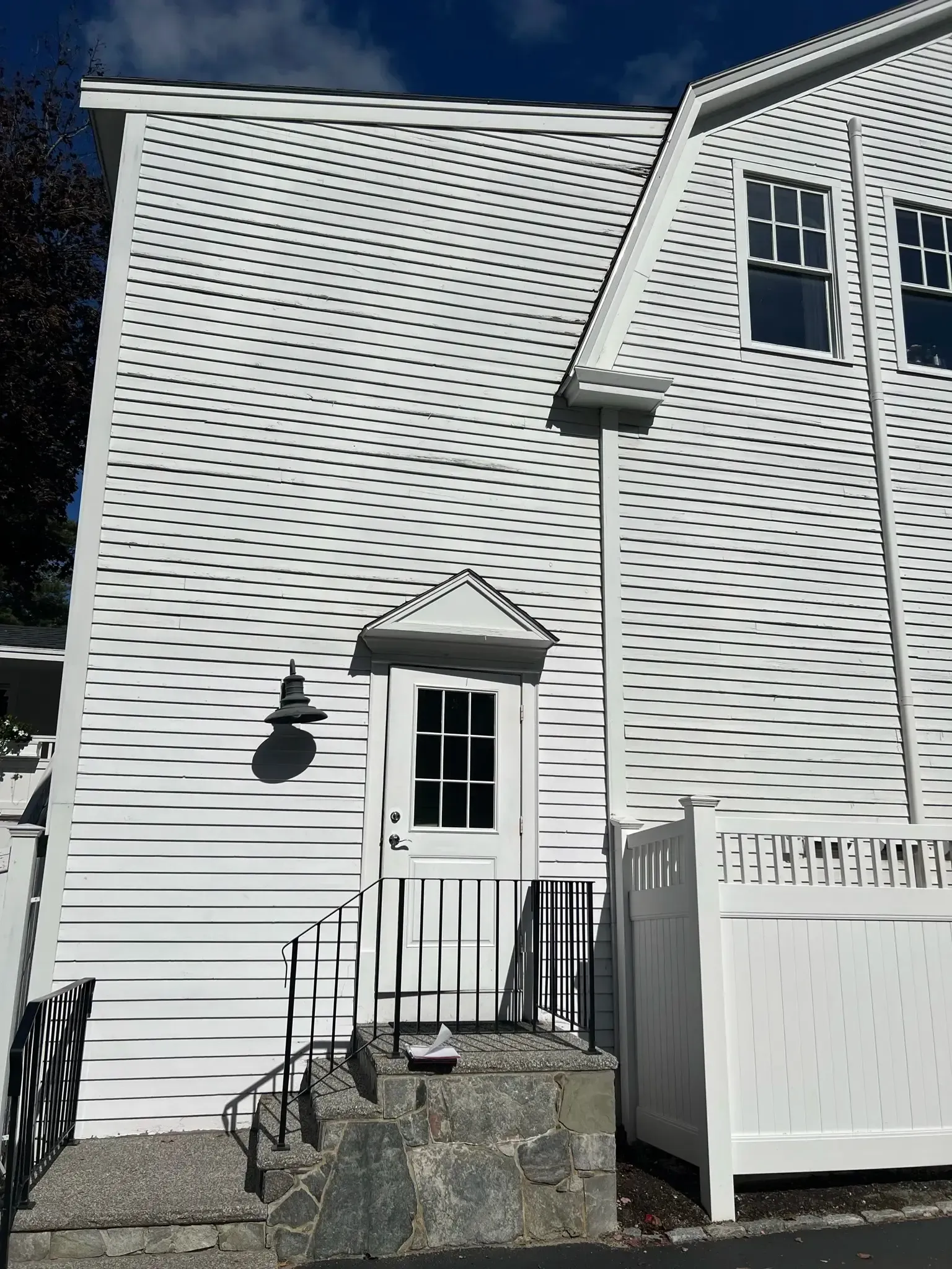 A white house with a white fence and stairs