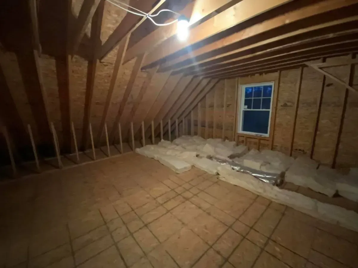 There is a window in the attic of a house under construction.