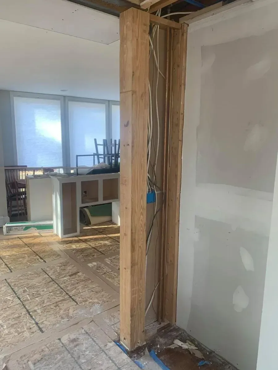 A room with a wooden pillar in the middle of it.