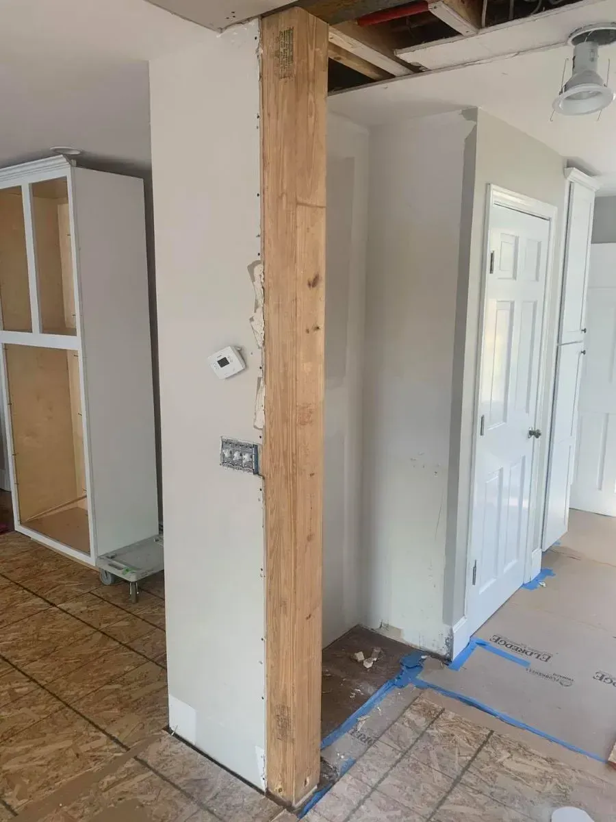 A room with a wooden post in the middle of it.