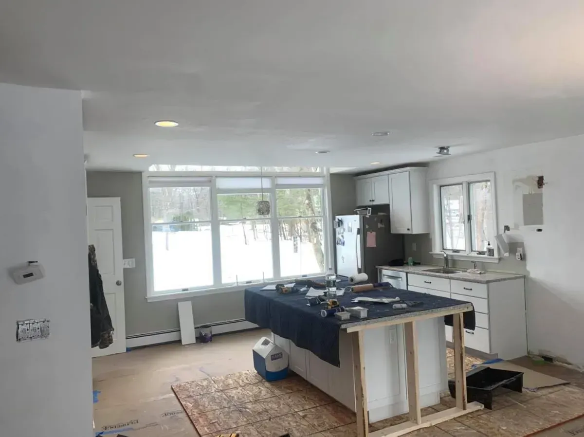 A kitchen under construction with a large island in the middle of the room.