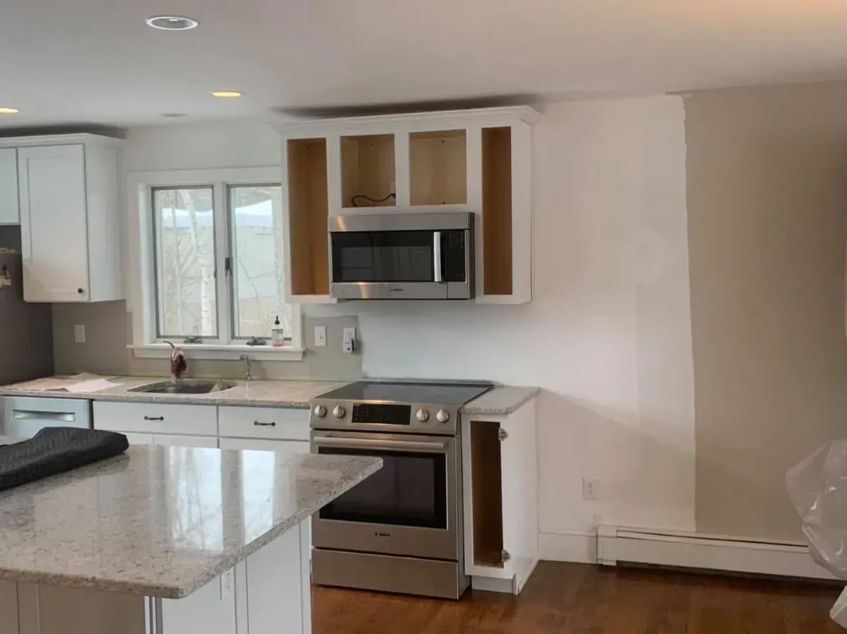 A kitchen with stainless steel appliances and white cabinets