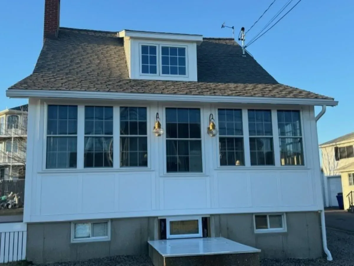 A white house with a lot of windows and a chimney
