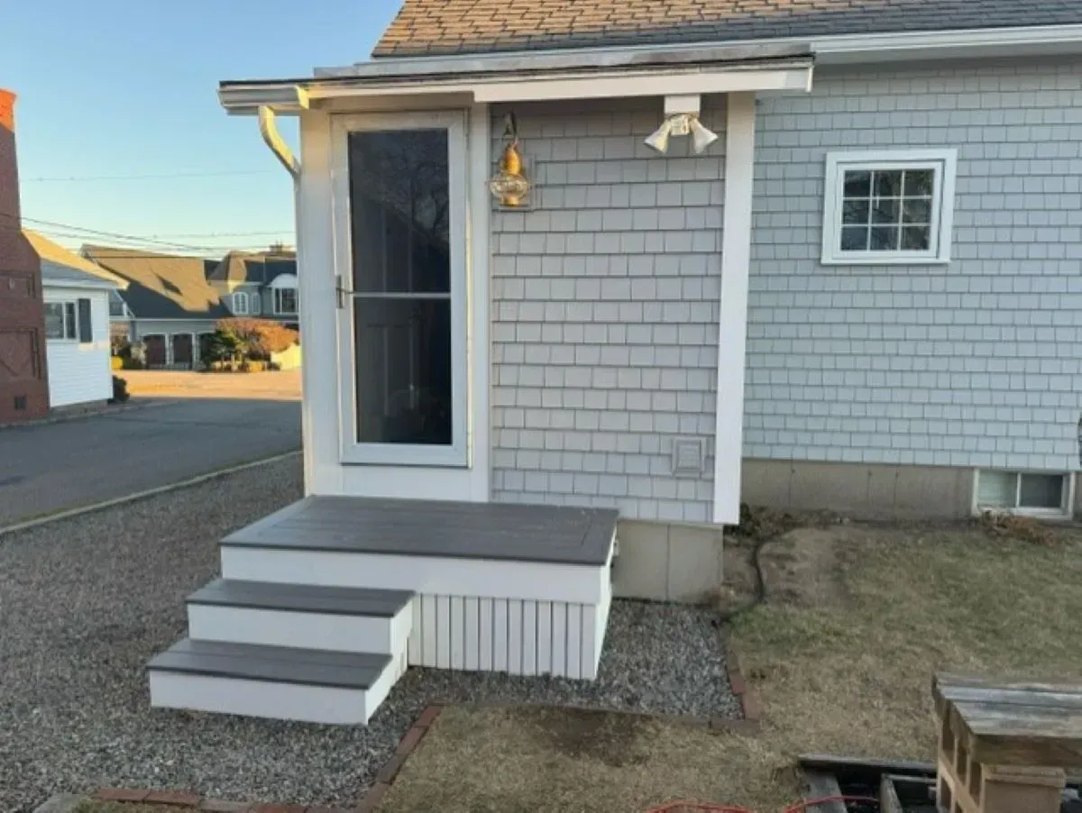 A small house with stairs leading up to the front door