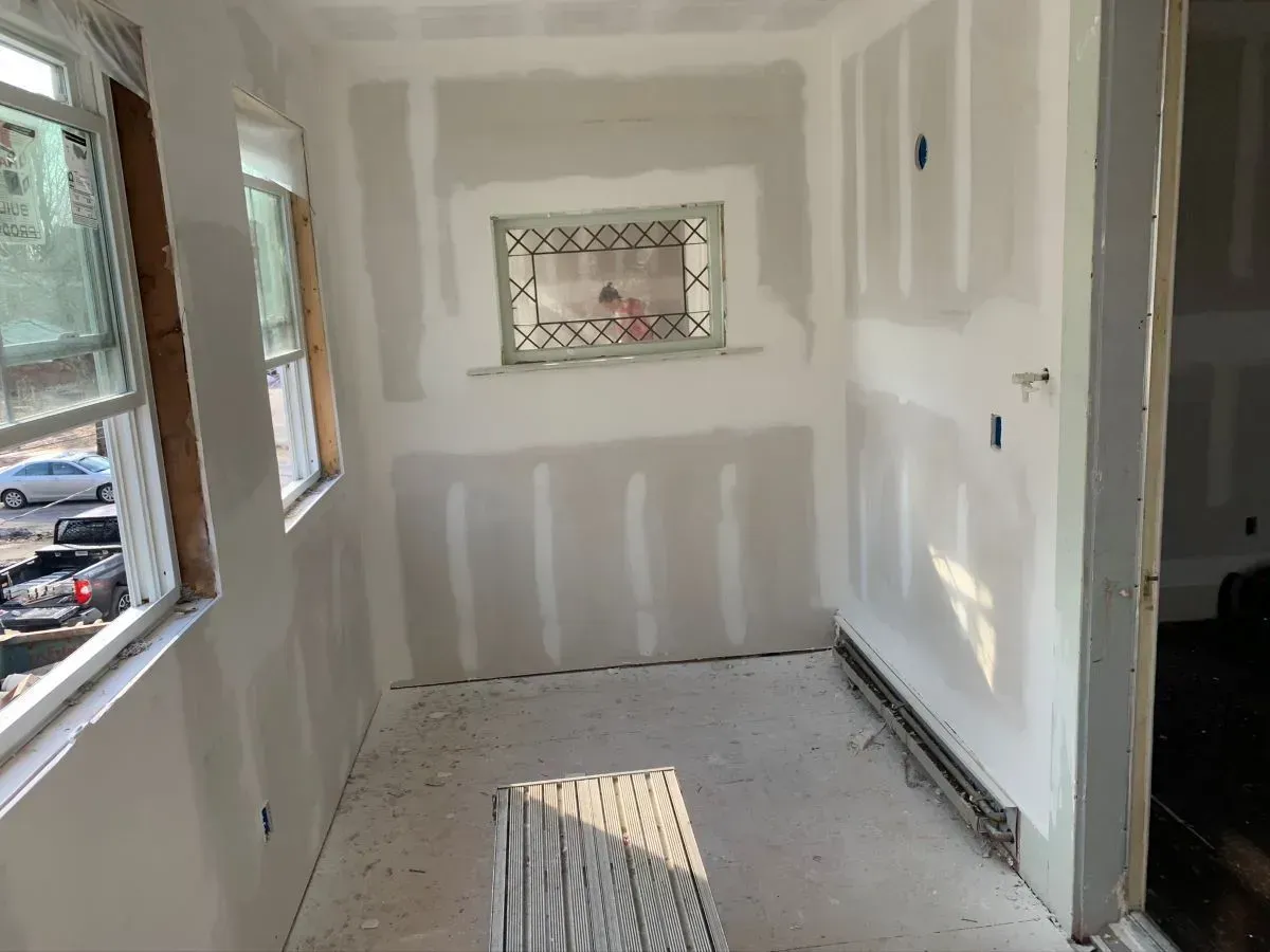 A room with drywall on the walls and a window.