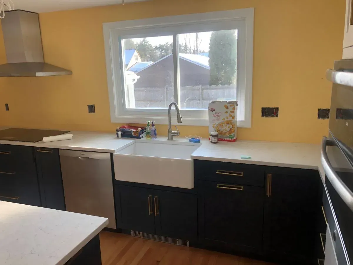 A kitchen with stainless steel appliances and a large window