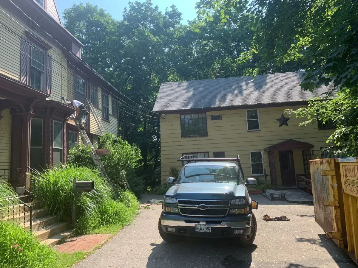 A blue truck is parked in front of a house