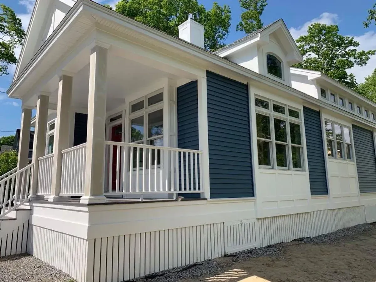 A white house with blue siding and a porch