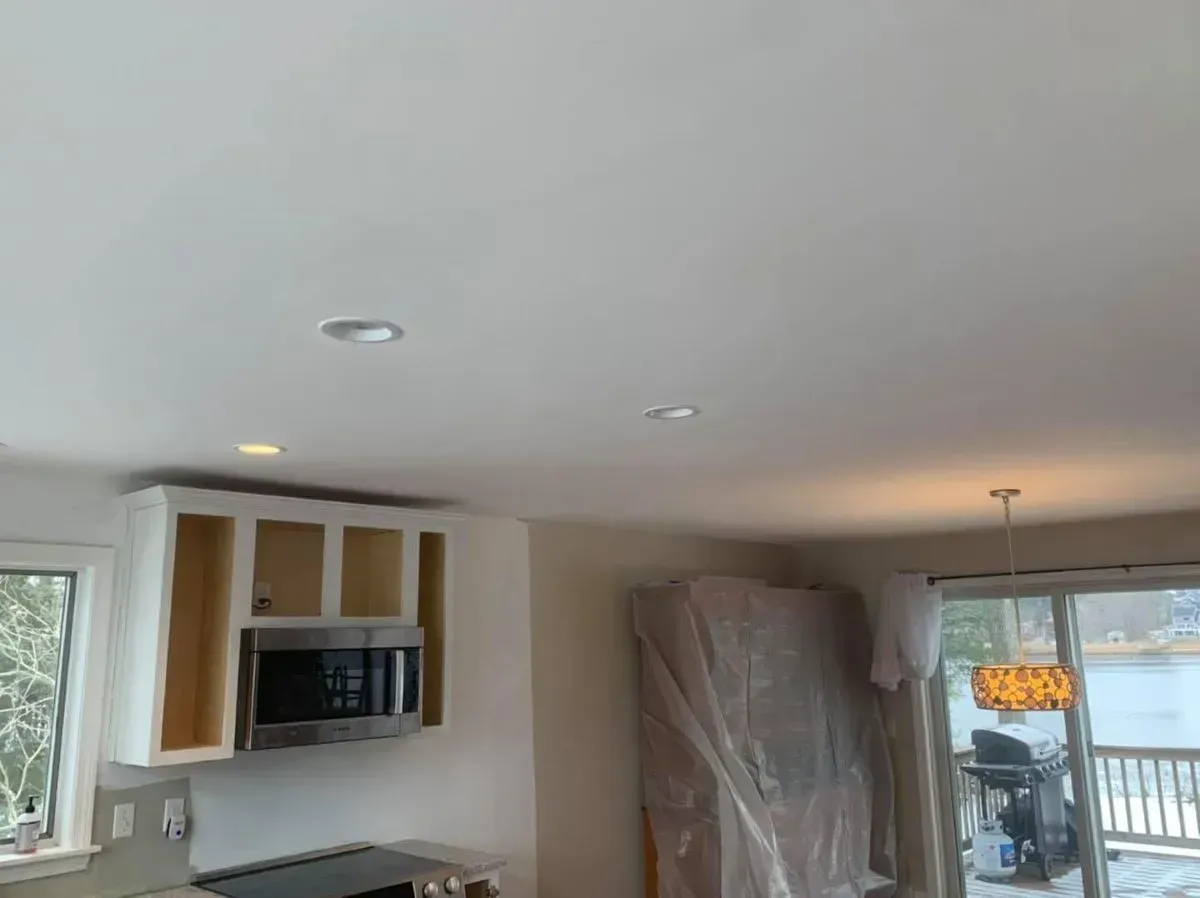 A kitchen with a stove , microwave , cabinets and a sliding glass door.